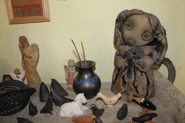 Dešinėje stovinti statulėlė lietuvaitė buvo laikoma tautodailininkės simboliu. Dauguma lėlių iš pirmosios personalinės parodos puikuojasi Mataičių dirbtuvėse. Autorės nuotr.
